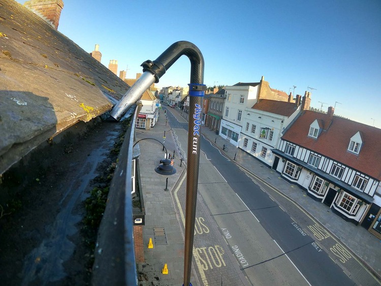 GoPro camera view showing SkyVac Elite pole cleaning gutters