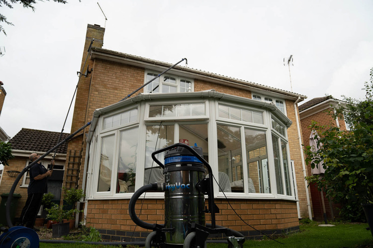 Professional gutter cleaning in Bramcote using SkyVac high-reach vacuum system over conservatory - no ladders required